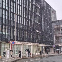 雪が降る中、傘を差して歩く人たち＝７日、成田市のＪＲ成田駅前