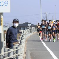 通常は入れない有料道路のコースで、沿道から応援を受けながら走るランナー＝２２日

