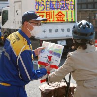 県警は、自転車で通りかかった人に「青切符」制度の事前啓発も実施した＝３月２４日、市川市