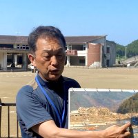 旧大川小学校で津波被害の語り部活動をする鈴木さん＝昨年６月
