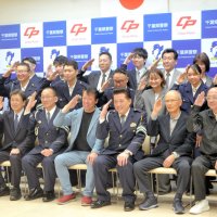 署員と記念写真に納まる秋山さん（中央）