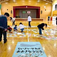 体育館の床に魚たちを並べる子どもたち（笠川さん提供）
